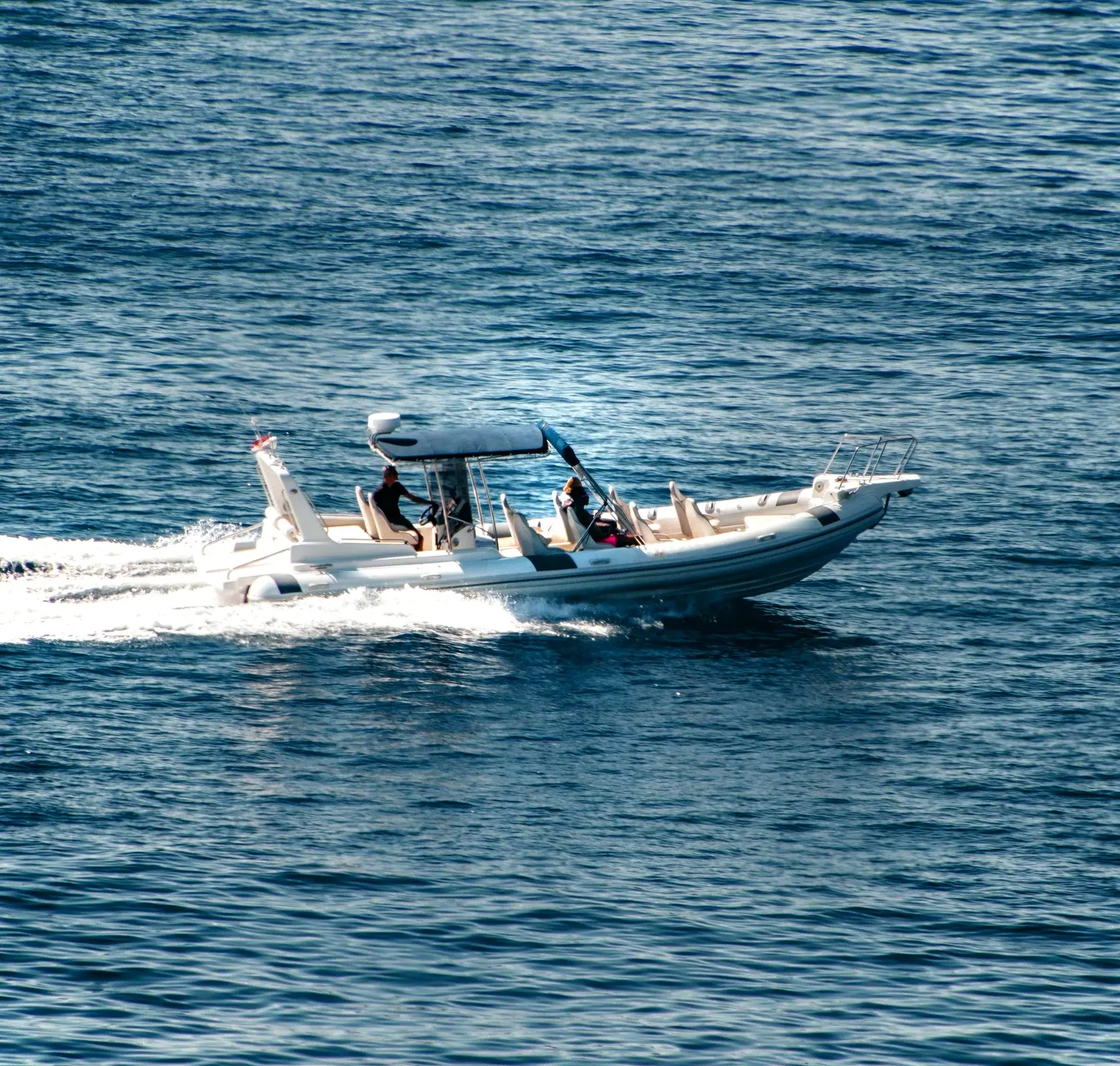 Grand semi-rigide à taud en route, long sillage blanc