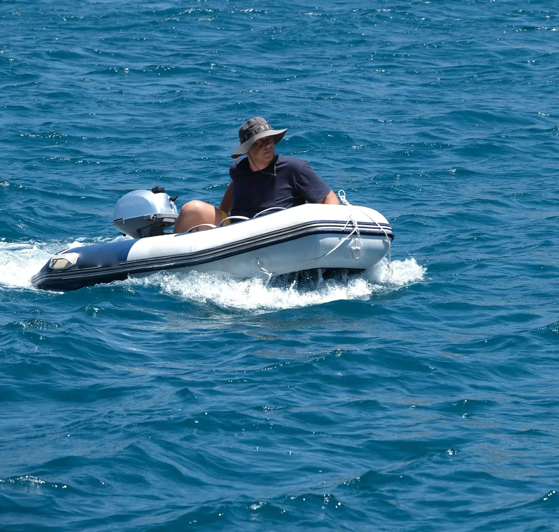 Petit semi-rigide à barre franche lancé sur une mer bleue