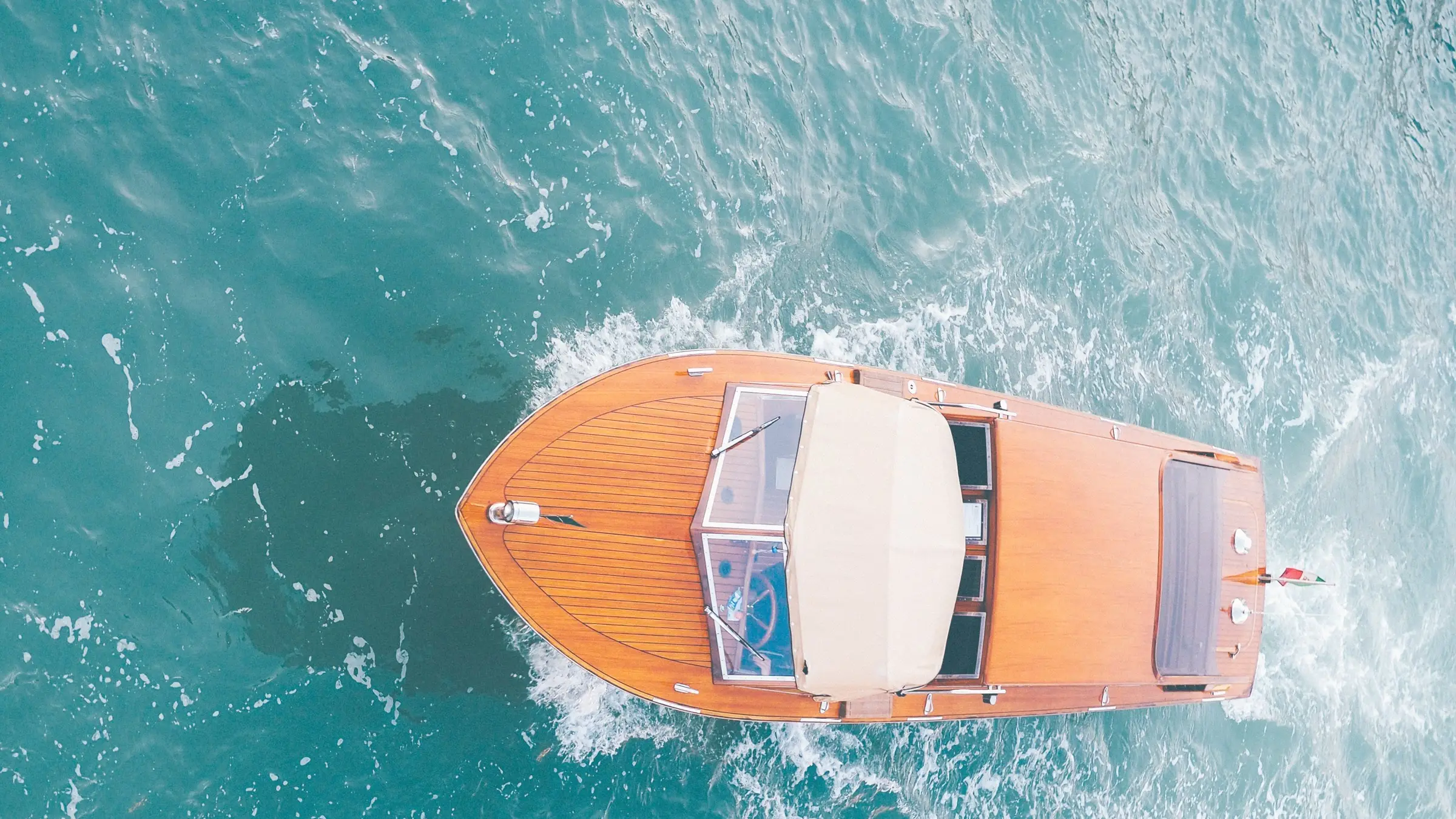Rabiou, runabout en acajou verni, vu du ciel sur une mer turquoise