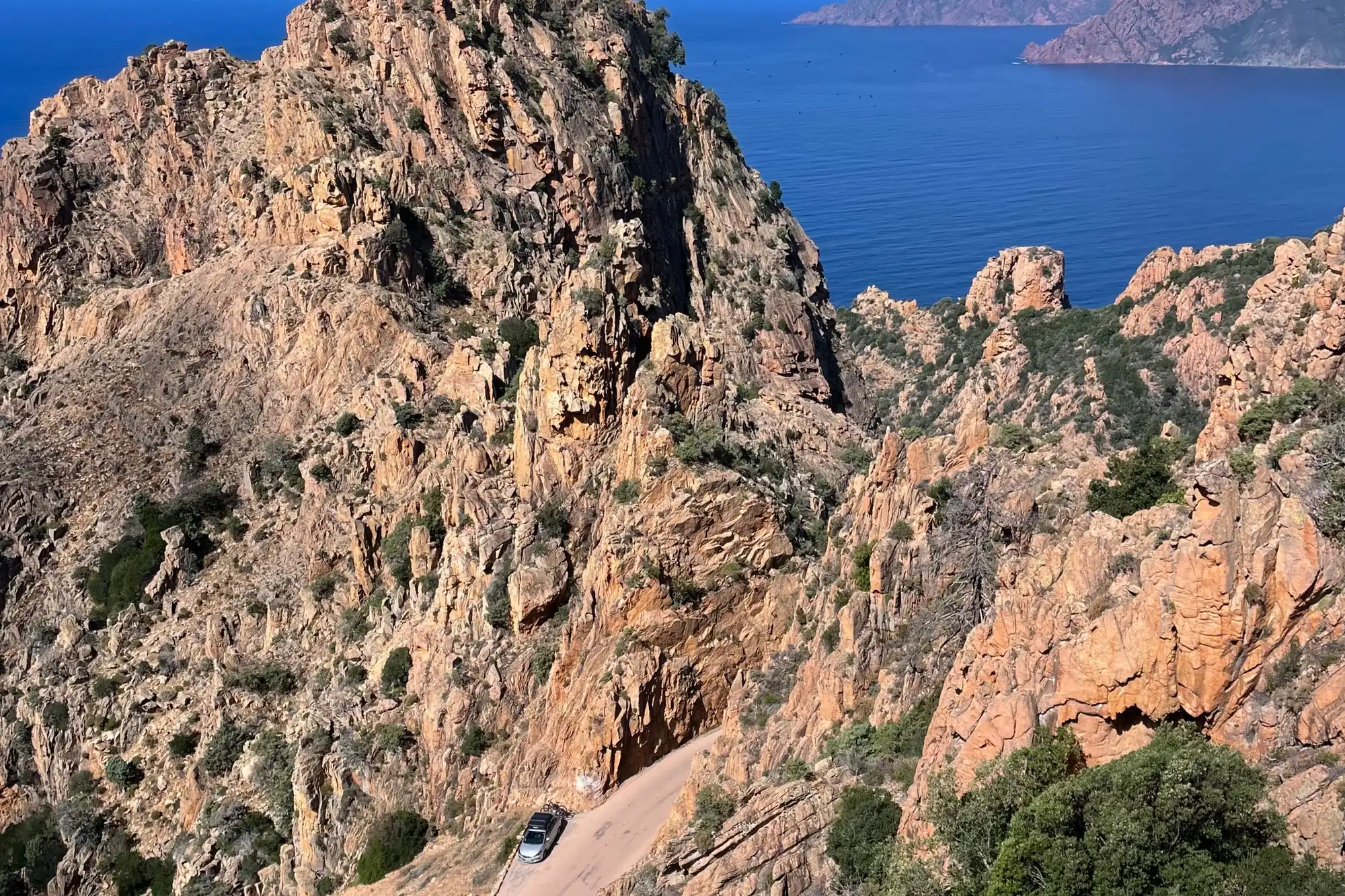 Les aiguilles des Calanche au-dessus du golfe de Porto, une route étroite en contrebas.
