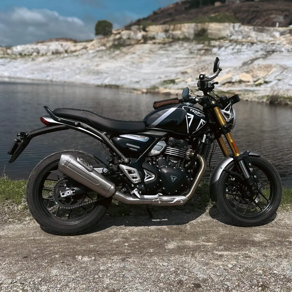 Triumph Speed 400 noire de profil, fourche dorée, au bord d’un plan d’eau