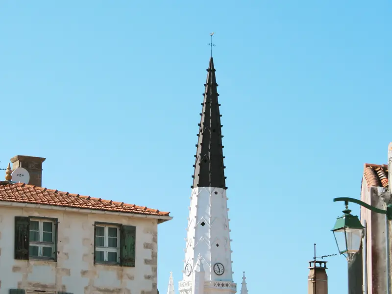 Rue d’Ars-en-Ré : volets verts et clocher noir et blanc.